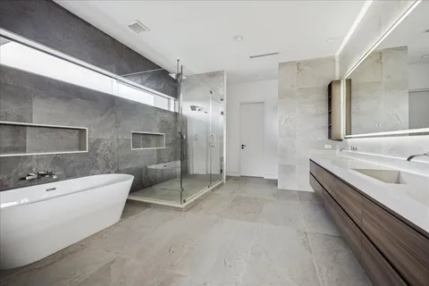 a spacious bathroom with a double vanity sink mirror and bathtub