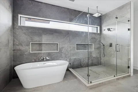 a white bath tub sitting next to a shower