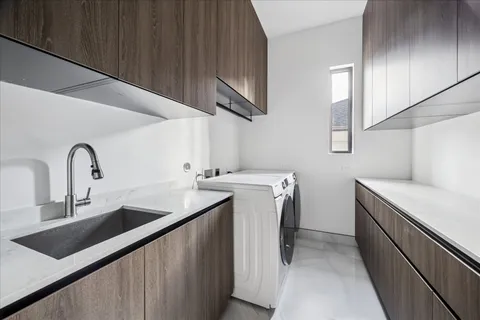 a utility room with sink dryer and washer