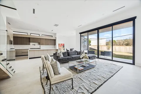 a living room with furniture large window and wooden floor