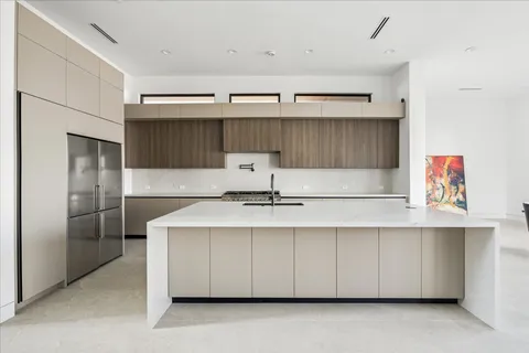 a kitchen with a sink a refrigerator and cabinets