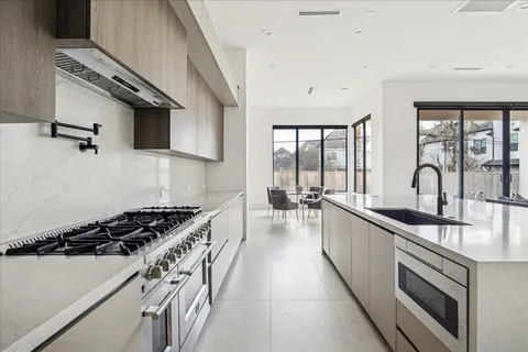 a kitchen with stainless steel appliances a sink a stove and cabinets