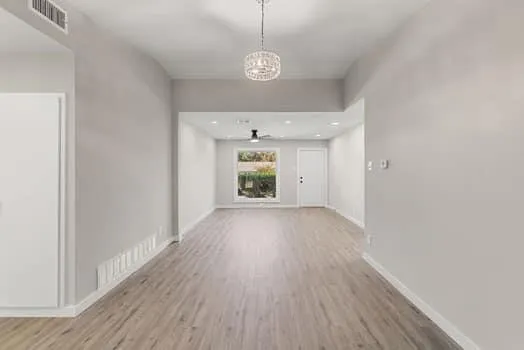 a view of a room with wooden floor and window