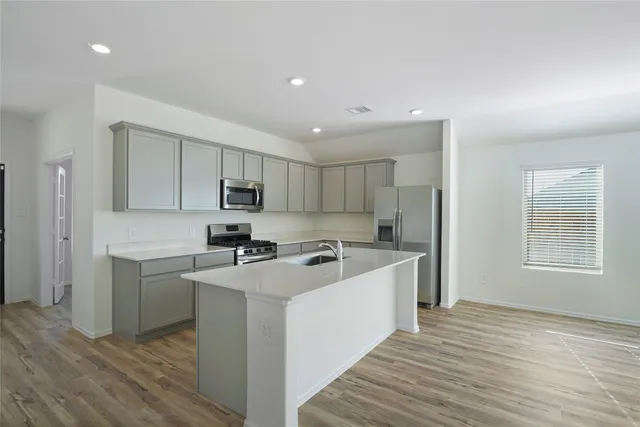 a kitchen with stainless steel appliances granite countertop a sink stove and refrigerator