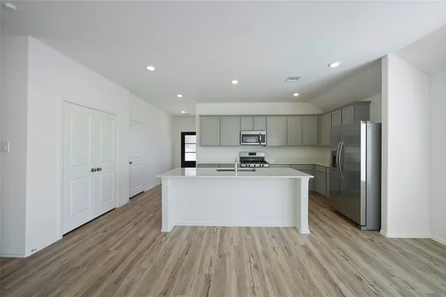 a view of kitchen with refrigerator sink and cabinets