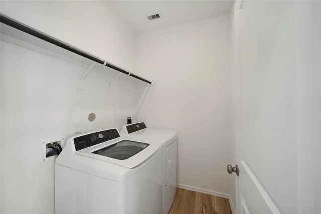 a view of empty room with wooden floor and window