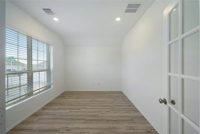 a view of a room with wooden floor and windows