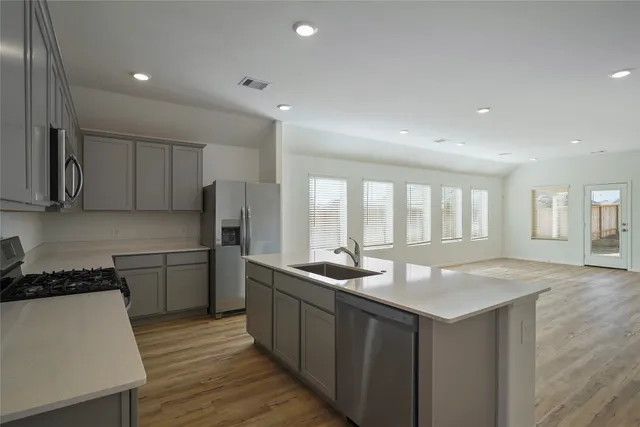 a kitchen with stainless steel appliances granite countertop a sink stove and refrigerator