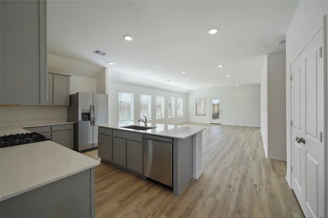 a kitchen with stainless steel appliances a sink a stove a refrigerator and cabinets