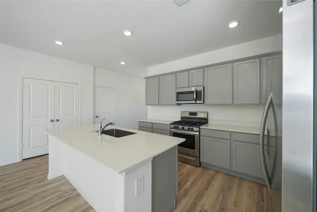 a kitchen with stainless steel appliances granite countertop a sink stove and refrigerator