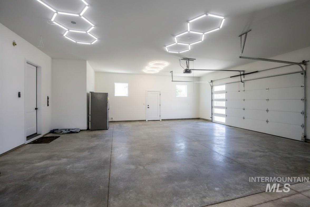 23904 Southview Lane Middleton, ID 83644 - Photo 16 of 29 Spacious garage featuring a concrete floor, two white access doors, and two windows
