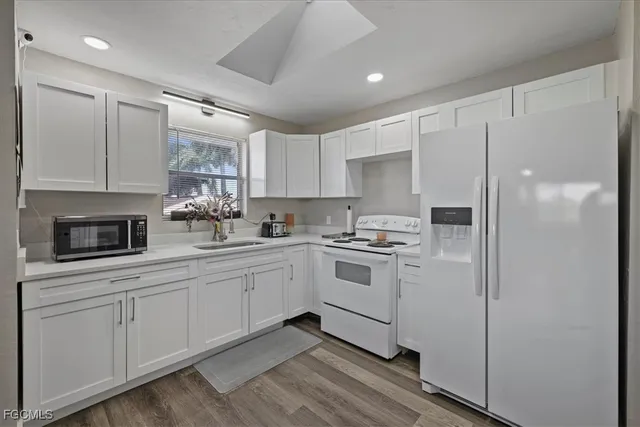 a kitchen with white cabinets and white appliances