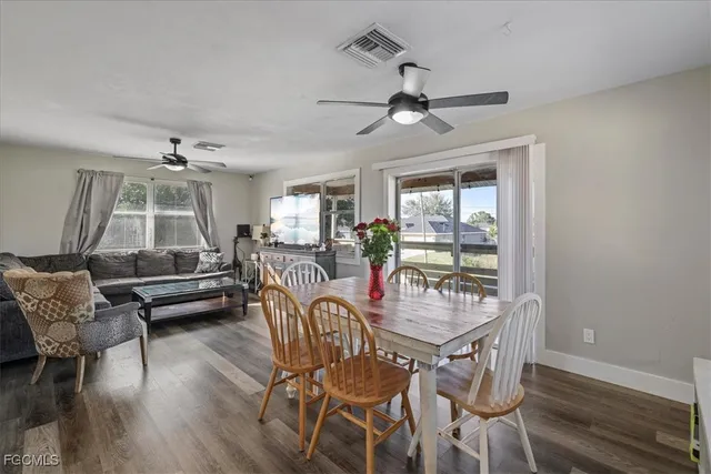 a dining room with furniture a chandelier and wooden floor