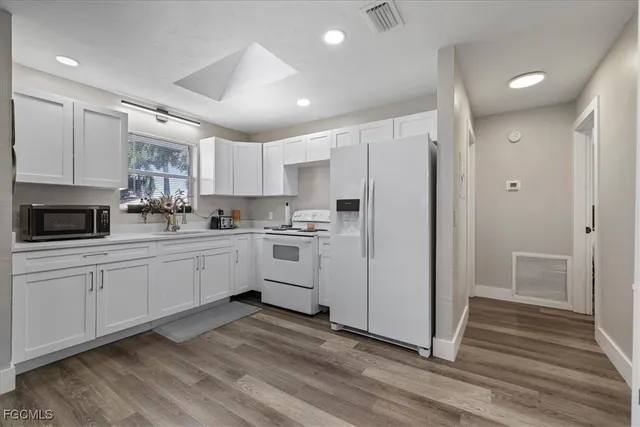 a kitchen with white cabinets and white appliances