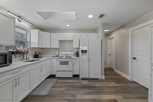a kitchen with white cabinets and white appliances