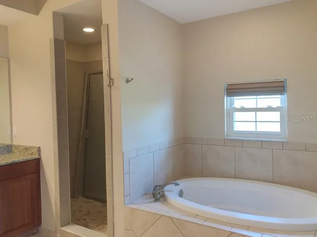 a white bath tub sitting in a bathroom near shower