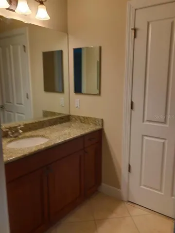 a bathroom with a granite countertop sink and mirror