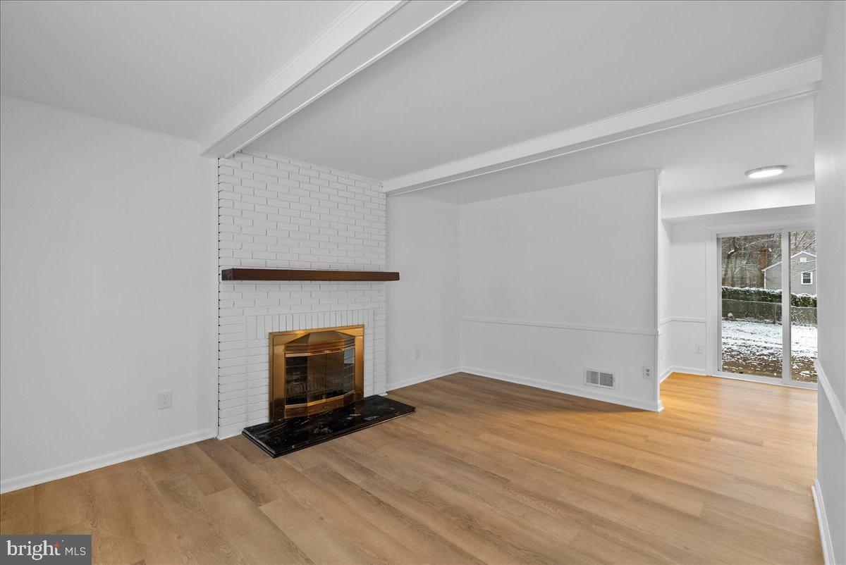 8608 Greeley Boulevard Springfield, VA 22152 - Photo 13 of 34 a view of an empty room with wooden floor and fireplace
