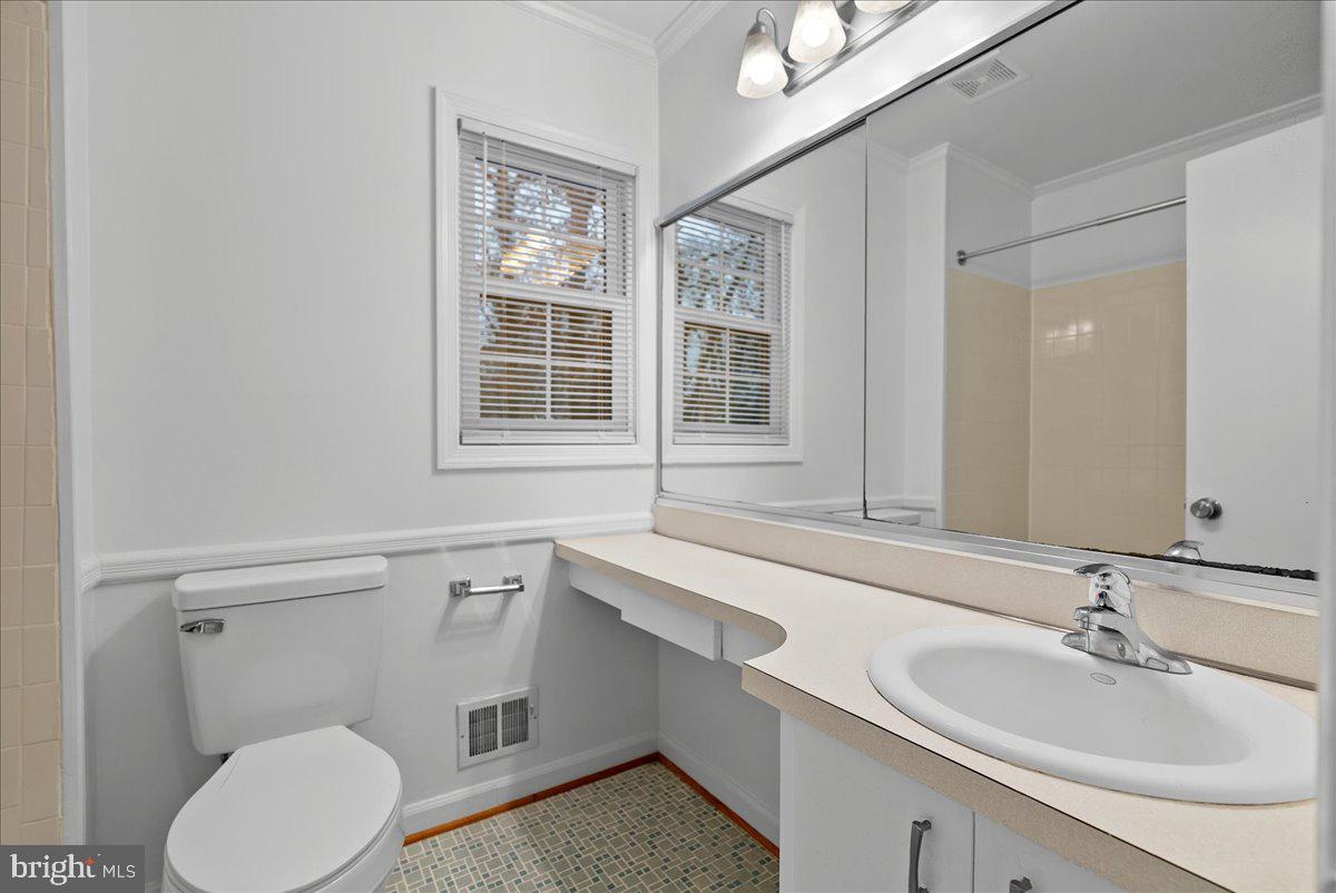 8608 Greeley Boulevard Springfield, VA 22152 - Photo 21 of 34 a bathroom with a sink vanity granite toilet and a mirror