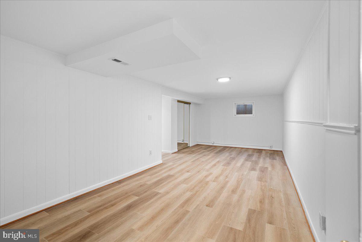 8608 Greeley Boulevard Springfield, VA 22152 - Photo 28 of 34 an empty room with wooden floor and windows
