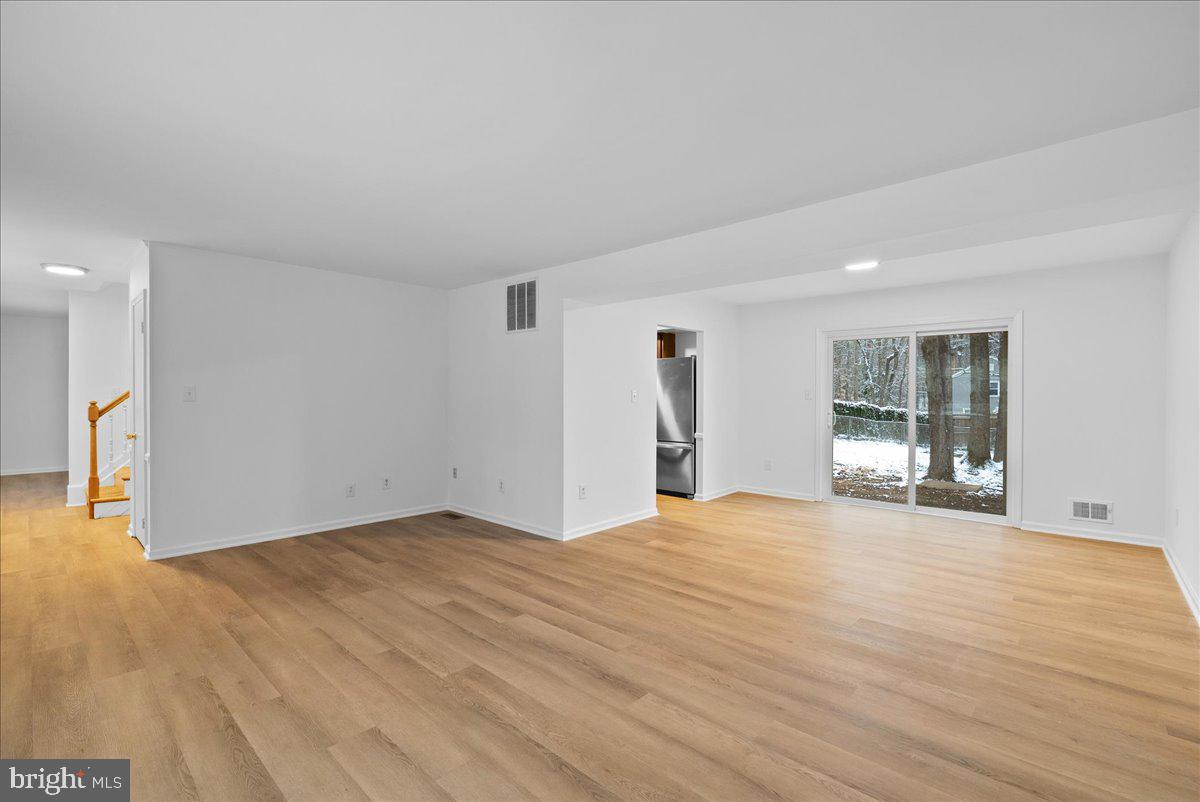 8608 Greeley Boulevard Springfield, VA 22152 - Photo 5 of 34 a view of an empty room with wooden floor and a window