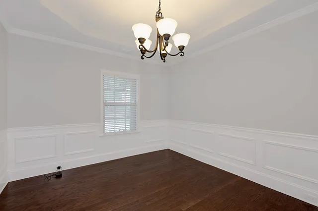 a view of a room with wooden floor and chandelier