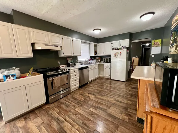 a kitchen with cabinets and wooden floor