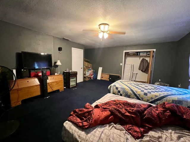 a bedroom with bed and a flat screen tv
