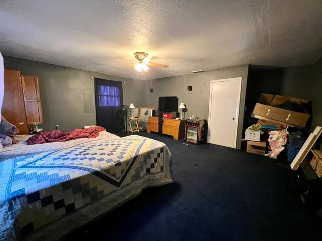 a bedroom with a bed and a mirror on the dresser