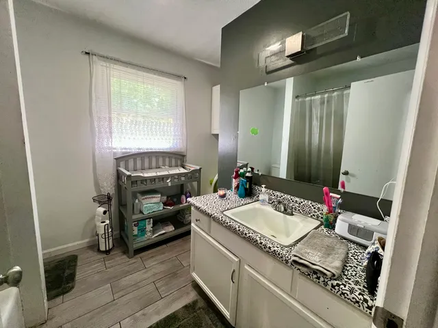a en suite bathroom with a granite countertop sink and a mirror