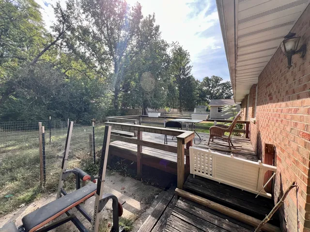 a view of a wooden chairs and table in the balcony