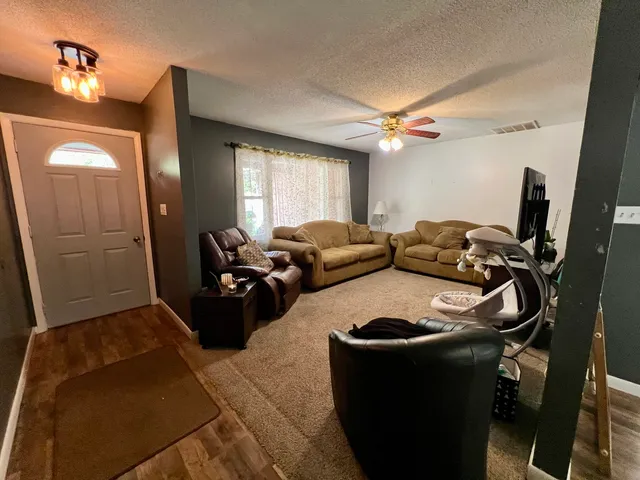a living room with furniture and a ceiling fan