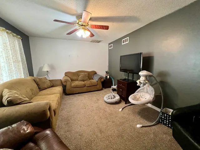 a living room with furniture a flat screen tv and a window