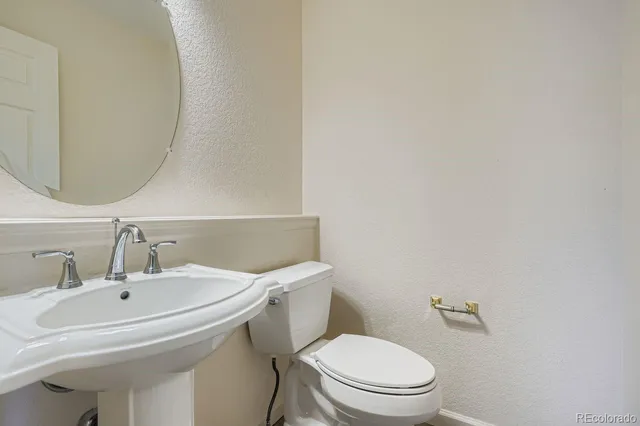 a bathroom with a sink a toilet and mirror