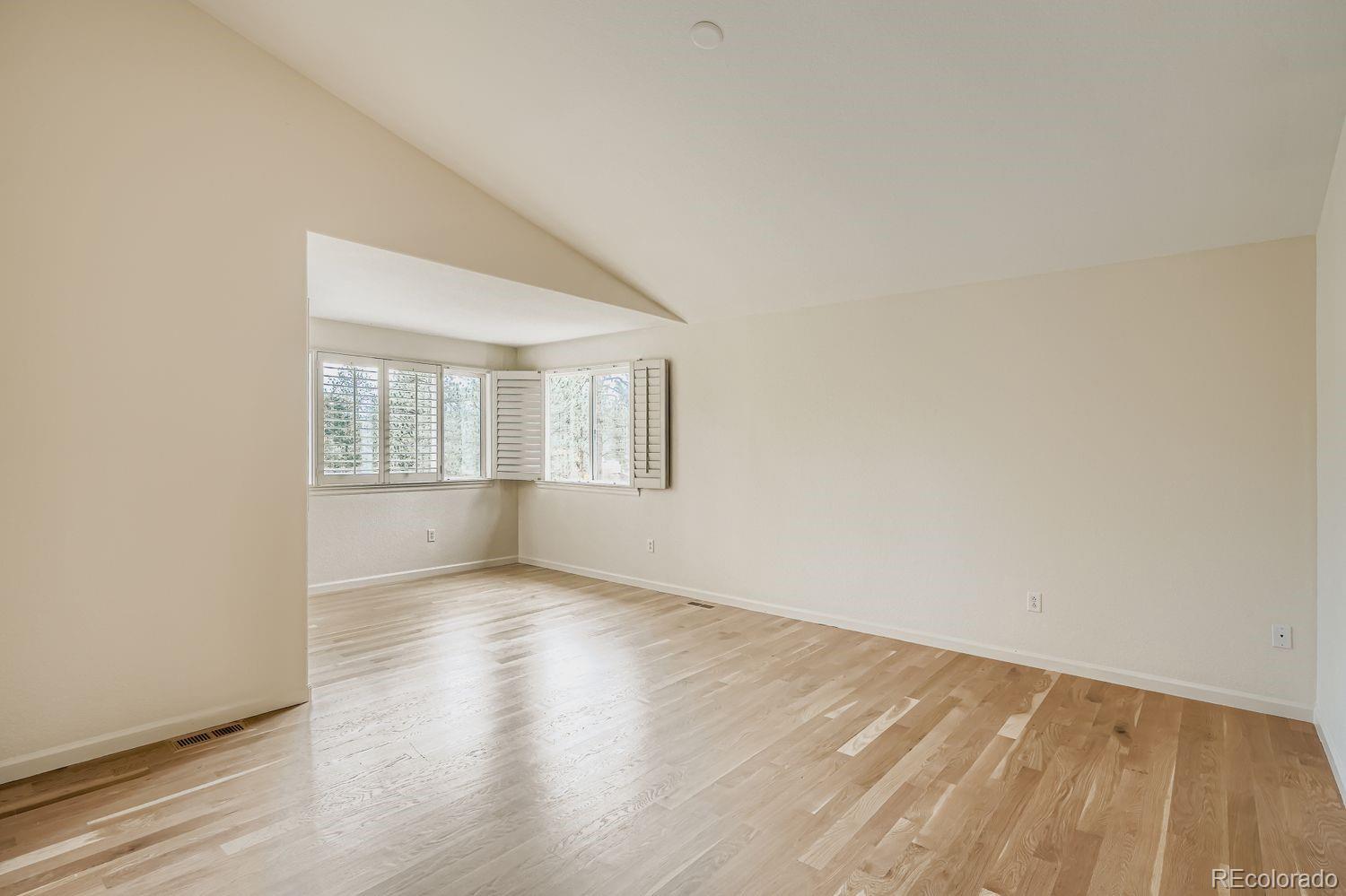 13637 Wamblee Trail Conifer, CO 80433 - Photo 12 of 30 an empty room with wooden floor and windows