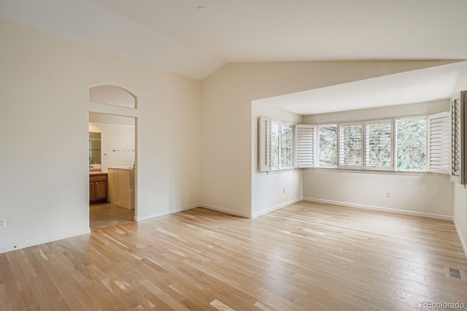 13637 Wamblee Trail Conifer, CO 80433 - Photo 13 of 30 an empty room with wooden floor and windows