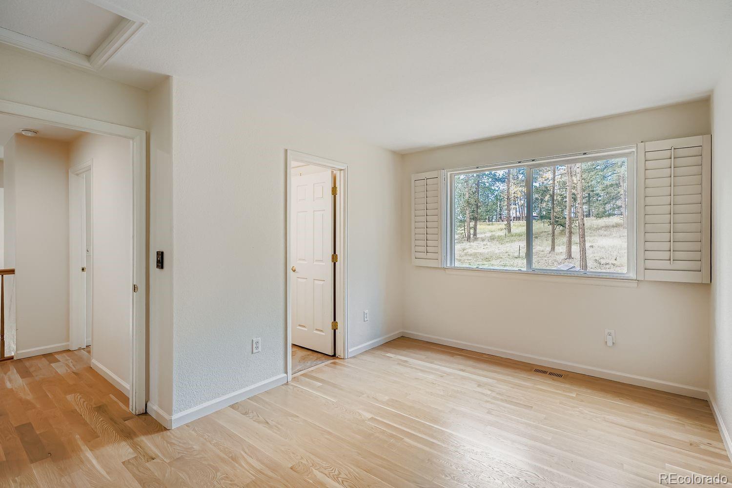 13637 Wamblee Trail Conifer, CO 80433 - Photo 19 of 30 a view of an empty room with wooden floor and a window