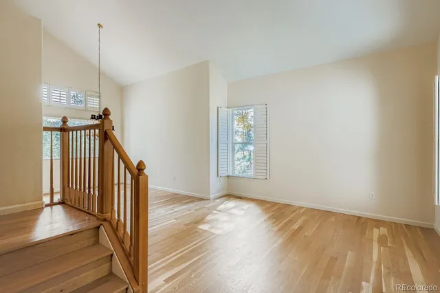 a view of a hallway with wooden floor and staircase