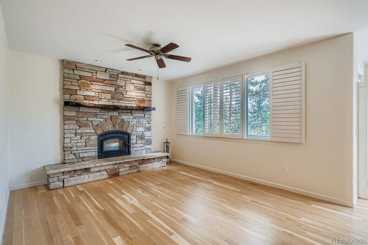 13637 Wamblee Trail Conifer, CO 80433 - Photo 9 of 30 a view of empty room with fireplace and fan