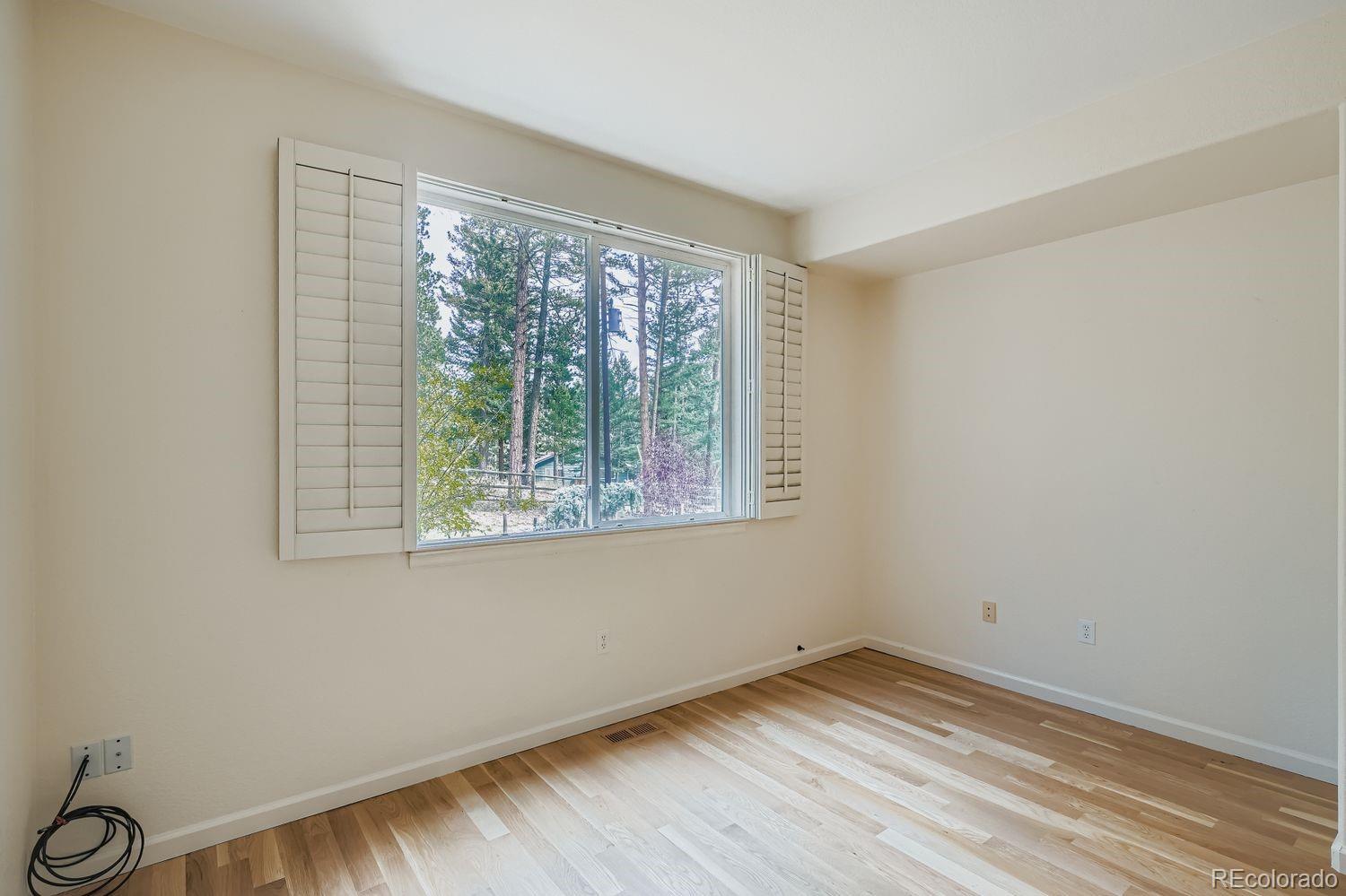 13637 Wamblee Trail Conifer, CO 80433 - Photo 10 of 30 a view of an empty room with wooden floor and a window