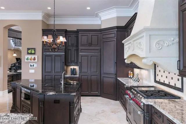 a very nice looking open dining room with kitchen island stainless steel appliances a couch dining table and chairs