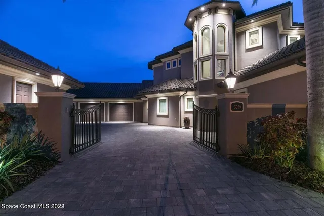a view of a house with many windows and plants
