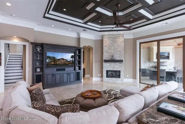 a living room with furniture a large window and a fireplace