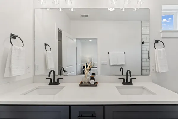 a bathroom with double vanity sinks and a mirror