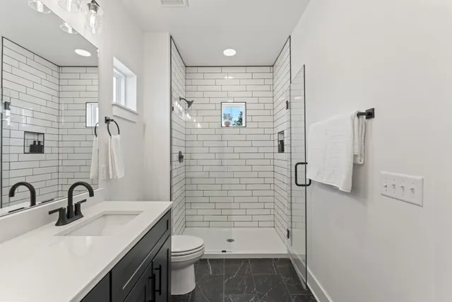 a bathroom with a sink a toilet and shower