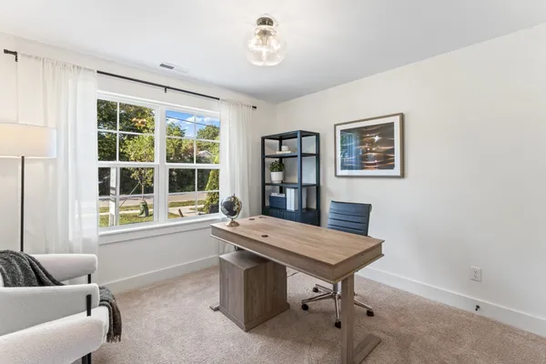 a view of a workspace with furniture and a window