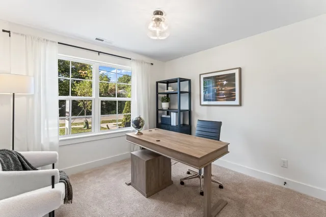 a view of a workspace with furniture and a window