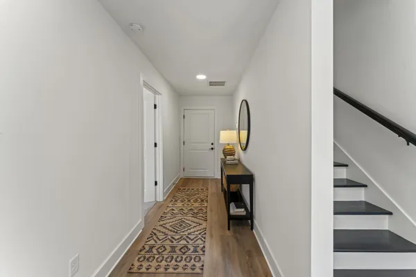a view of hallway with wooden floor and stairs