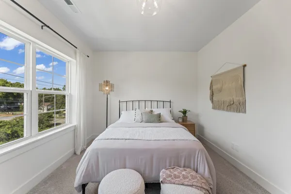 a bedroom with a bed and a large window