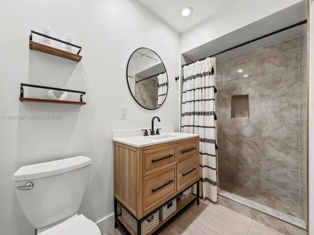 a bathroom with a sink a toilet and a mirror